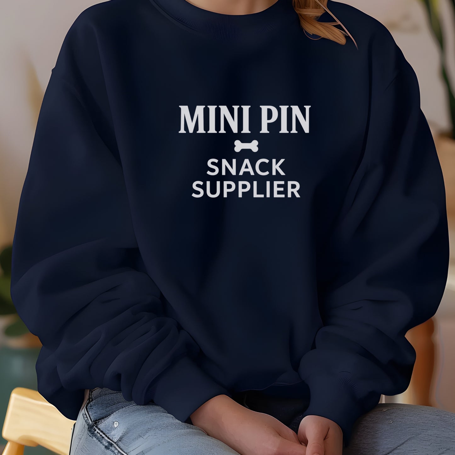 Woman wearing anavy "Mini Pin Snack Supplier" Miniature Pinscher unisex sweatshirt indoors.