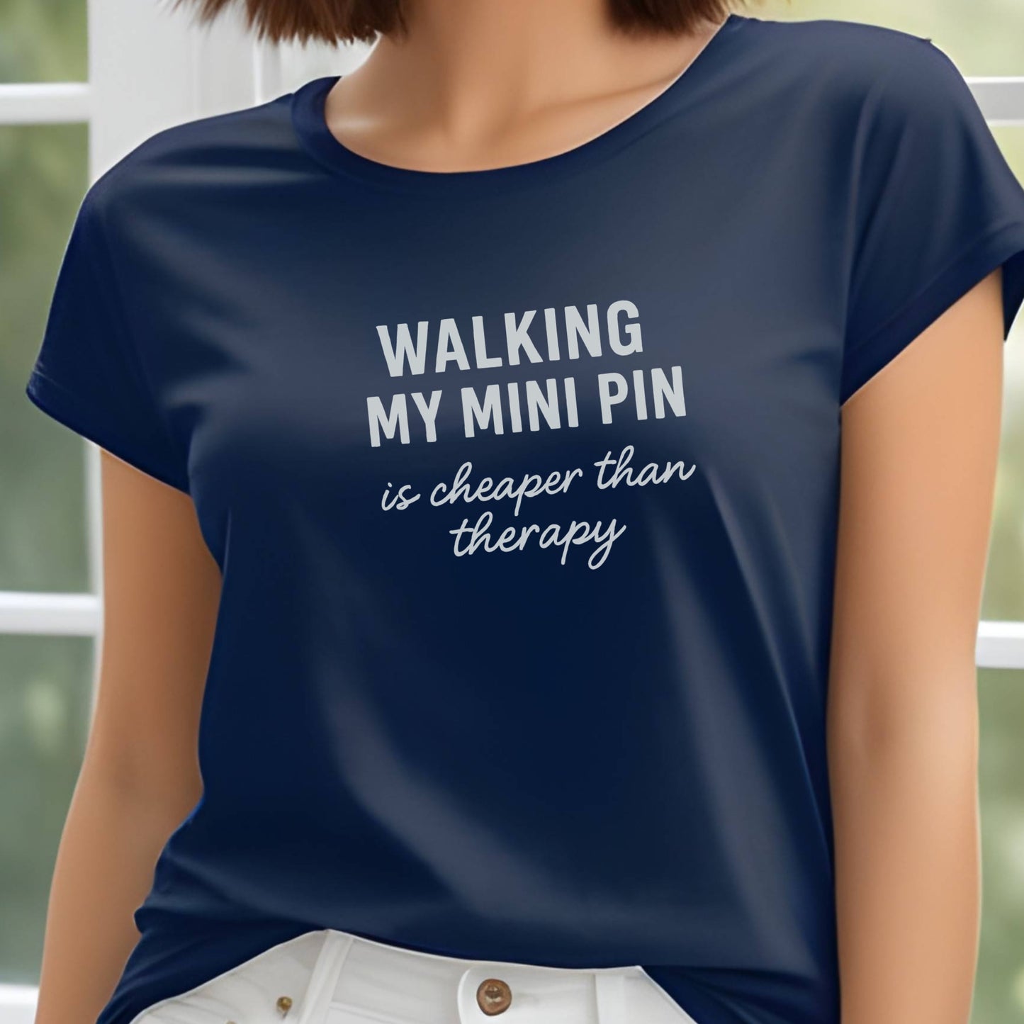 Navy unisex t-shirt with white text: "WALKING MY MINI PIN is cheaper than therapy" centered on chest