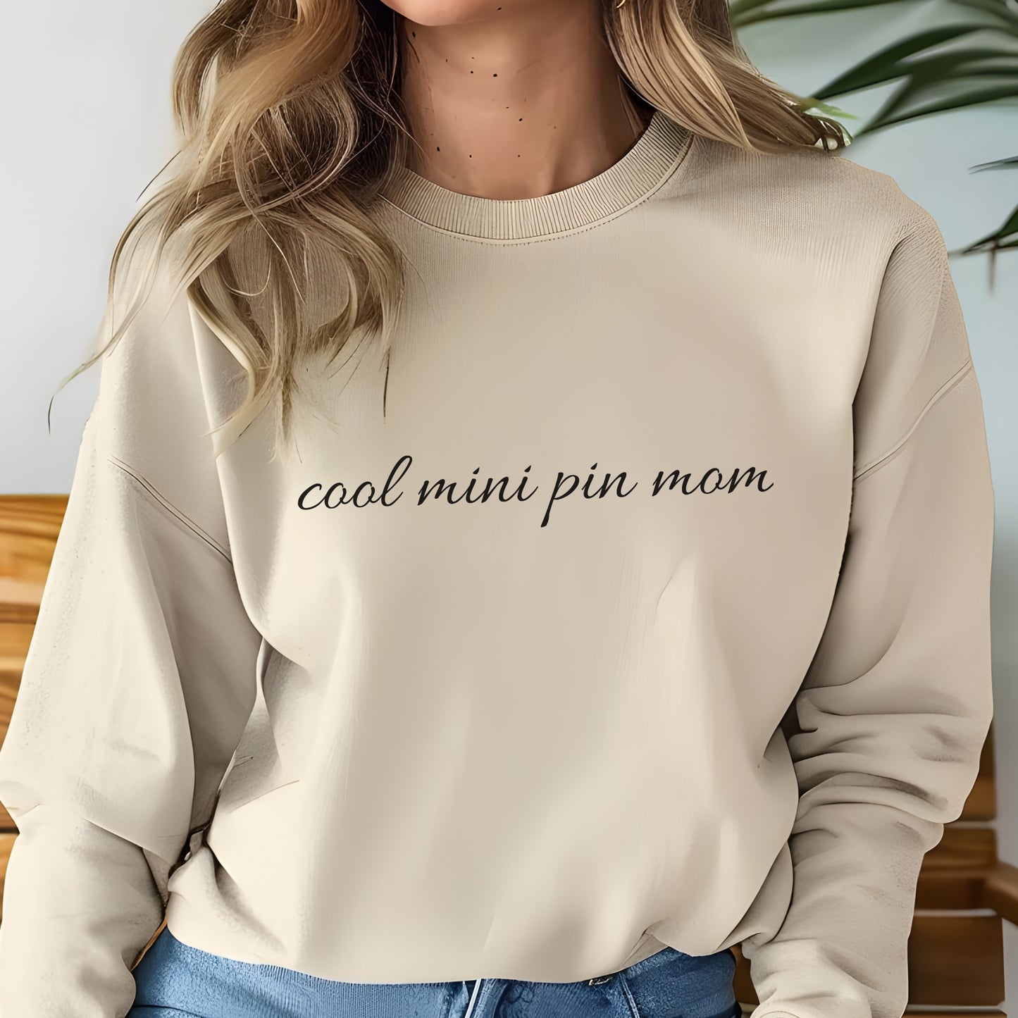 Woman wearing asand "cool mini pin mom" Miniature Pinscher women’s sweatshirt, hands in pockets, casual style