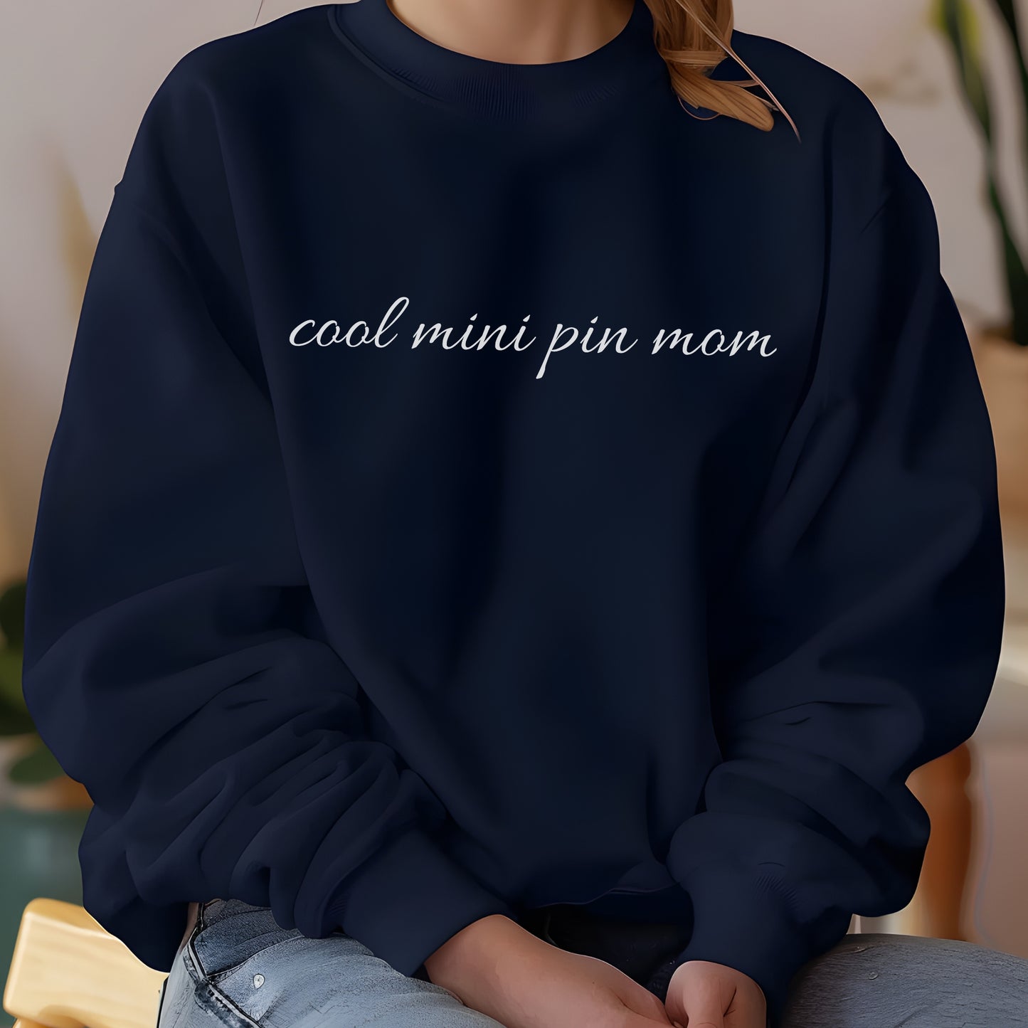 Woman wearing a navy "cool mini pin mom" Miniature Pinscher women’s sweatshirt, hands in pockets, casual style