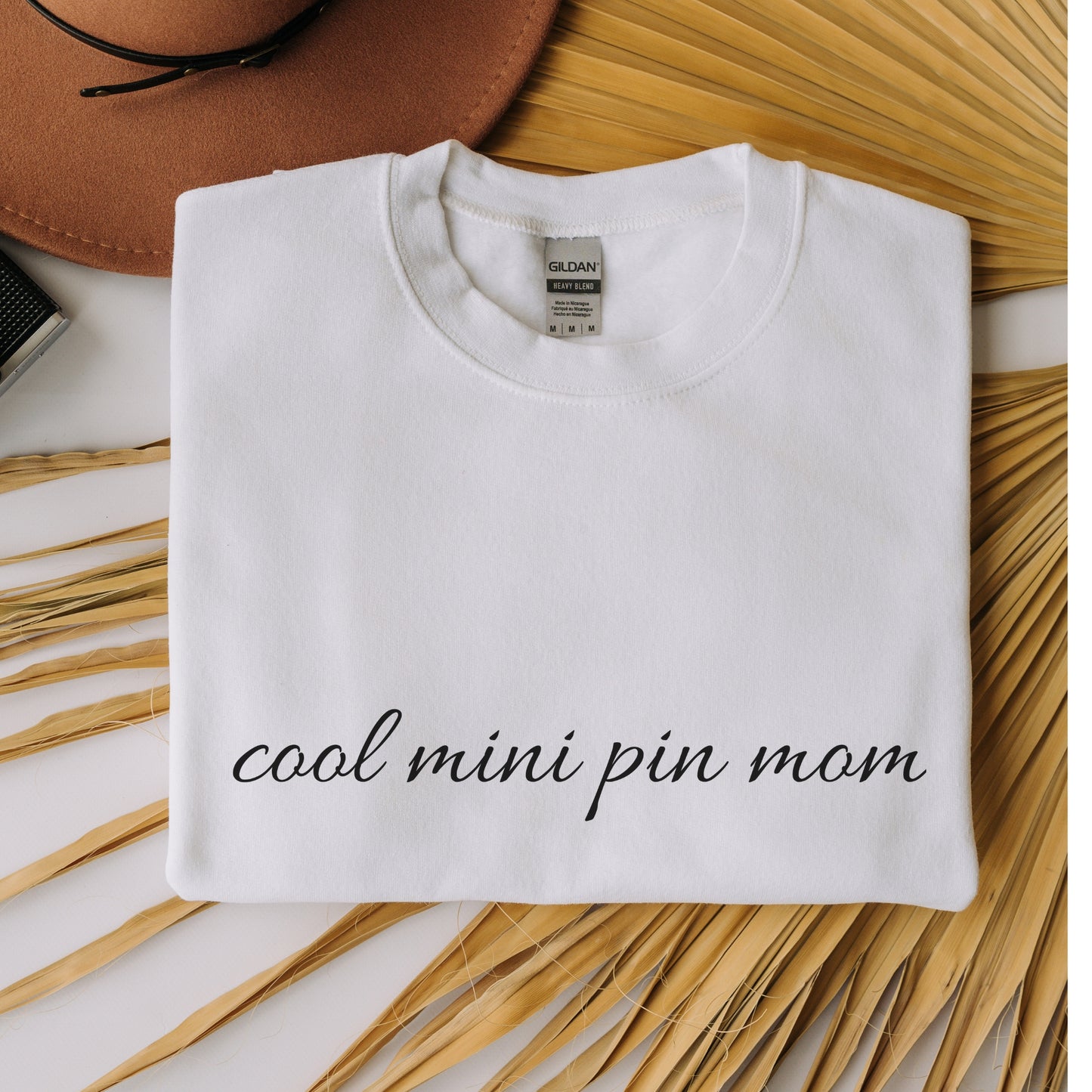 Flat lay white "cool mini pin mom" Miniature Pinscher women’s sweatshirt, hands in pockets, casual style