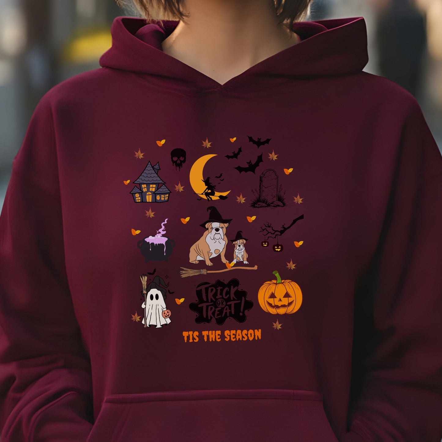 Maroon hoodie with Halloween themed dog and spooky icons, “Trick or Treat ‘Tis the Season” text, festive autumn design