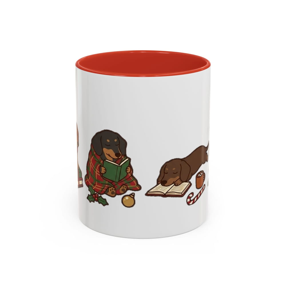 A white ceramic mug with a bright red interior, featuring a cartoon illustration of two dachshunds reading books on the side.