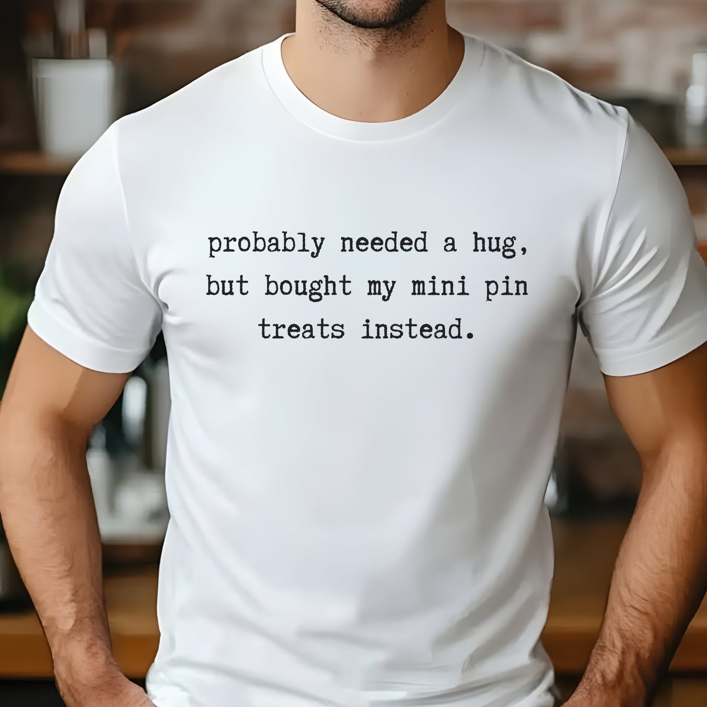 White unisex t-shirt with white text: "probably needed a hug, but bought my mini pin treats instead."