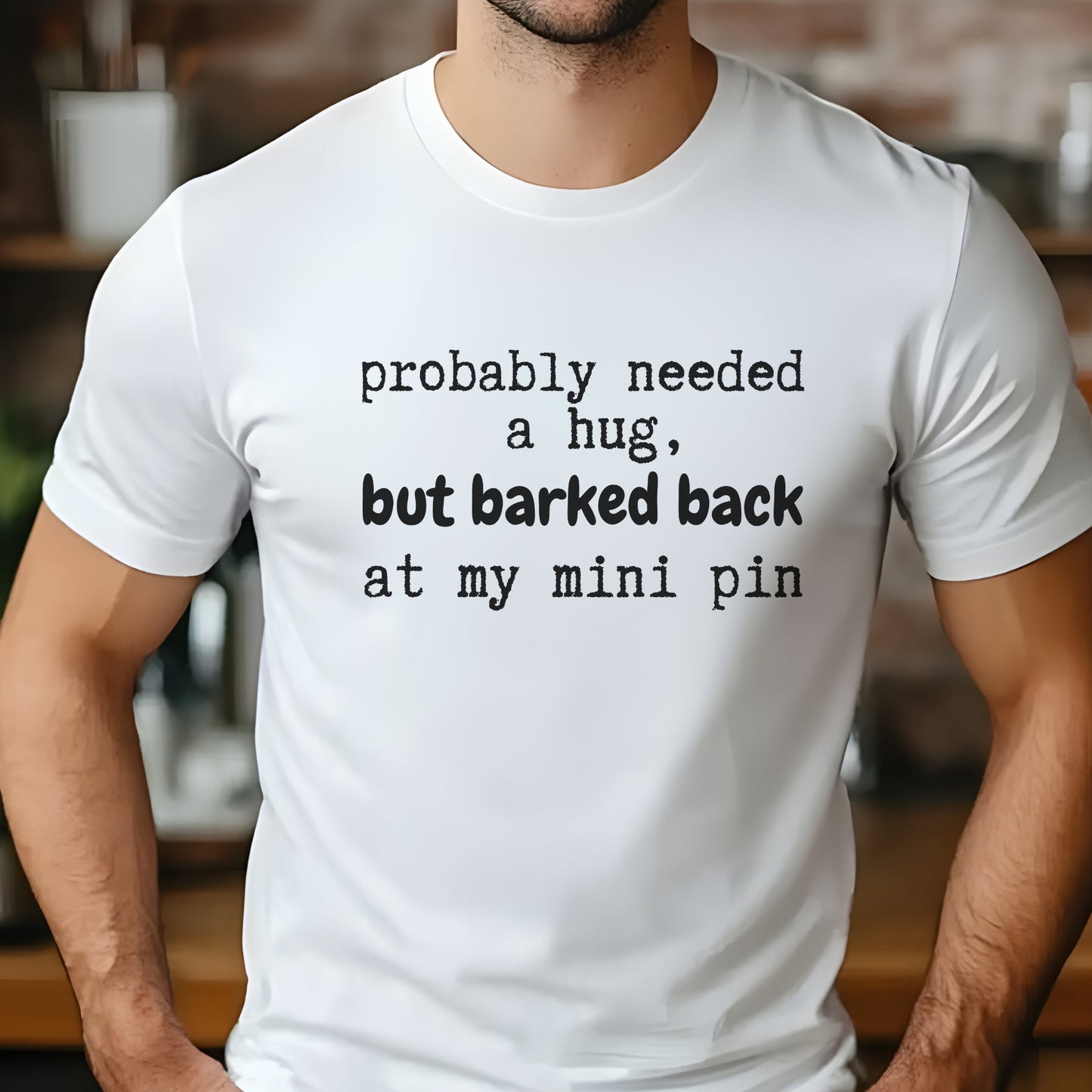 White unisex t-shirt with white text: "probably needed a hug, but barked back at my mini pin" centered on the chest