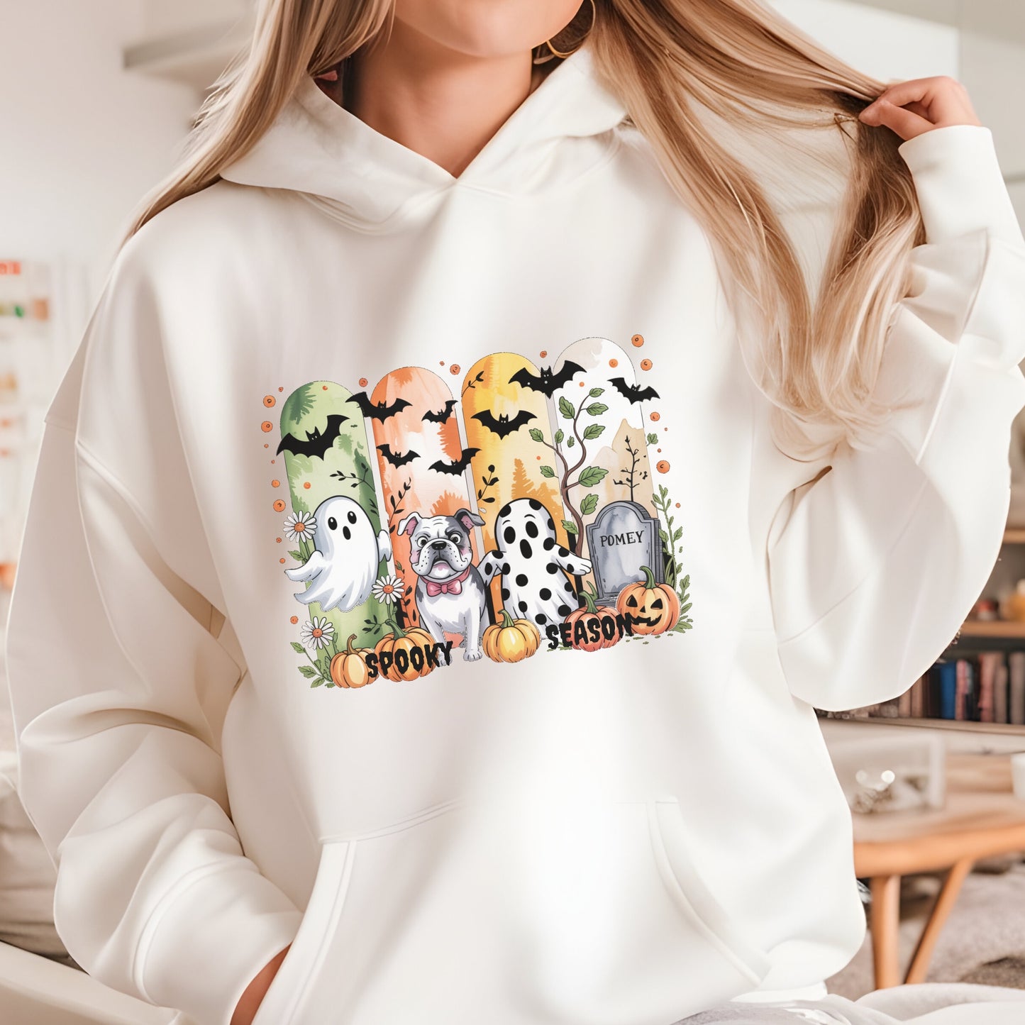 Sand colored hoodie with Halloween-themed print of small dogs in ghost costumes, bats, pumpkins, and “Spooky Season” text on the front.
