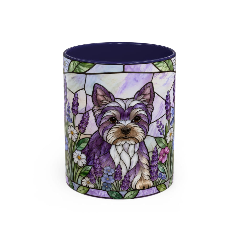 A ceramic mug featuring a stained-glass style illustration of a Yorkshire Terrier surrounded by lavender and white flowers, with a dark navy blue interior and rim.