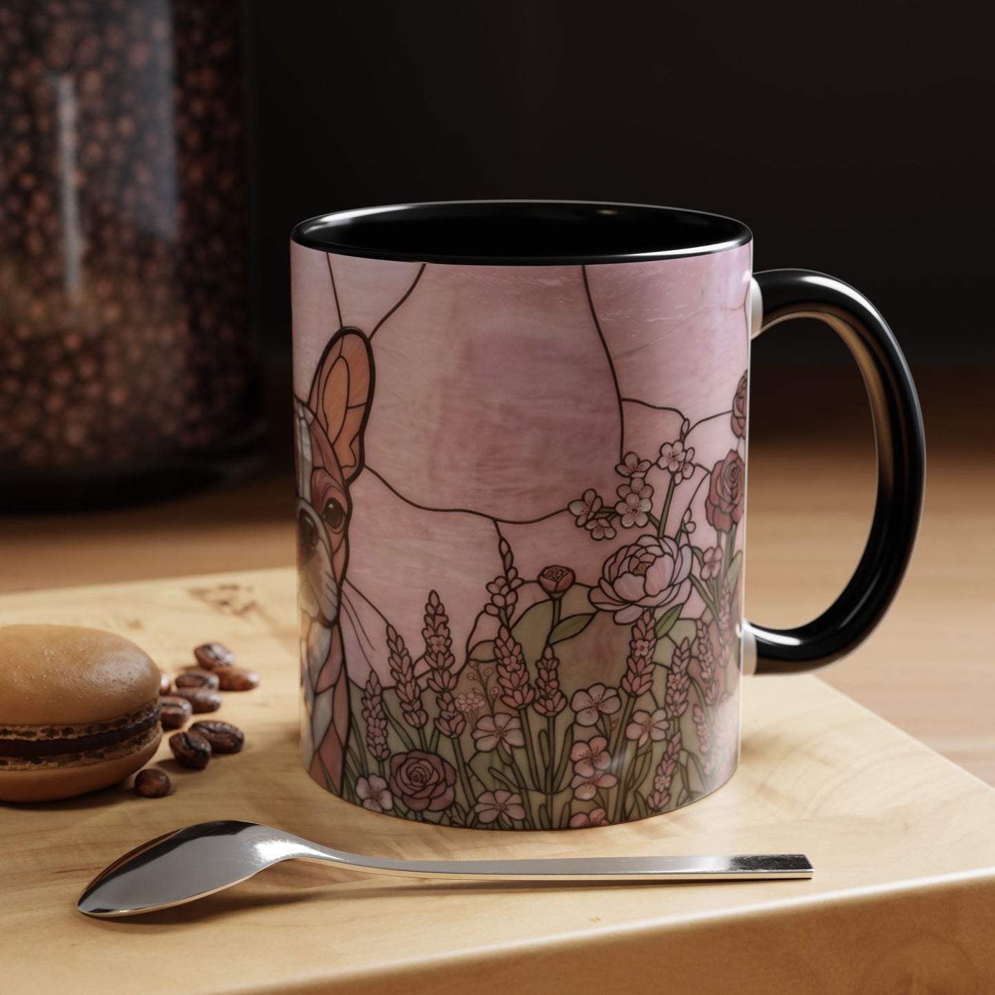 Mug with a deer and floral design on a wooden surface with coffee beans and a spoon.