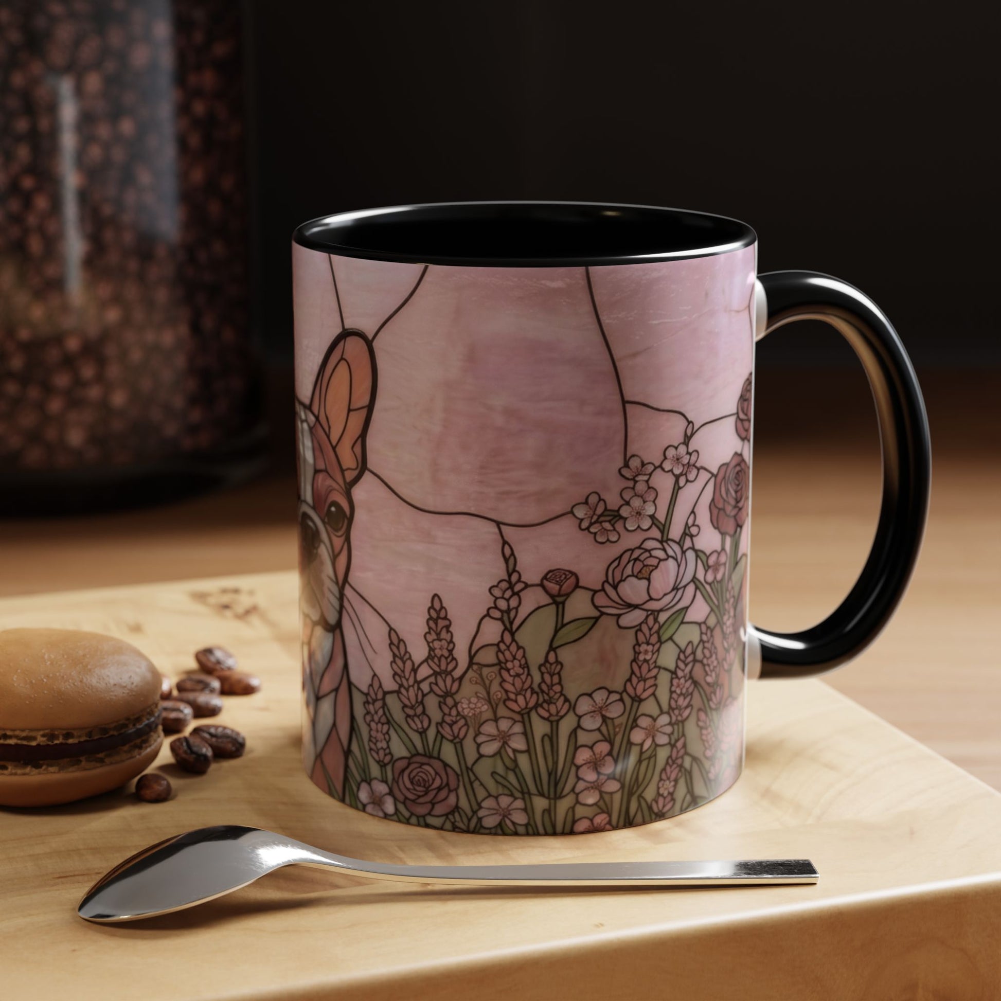 Mug with a deer and floral design on a wooden surface with coffee beans and a spoon.