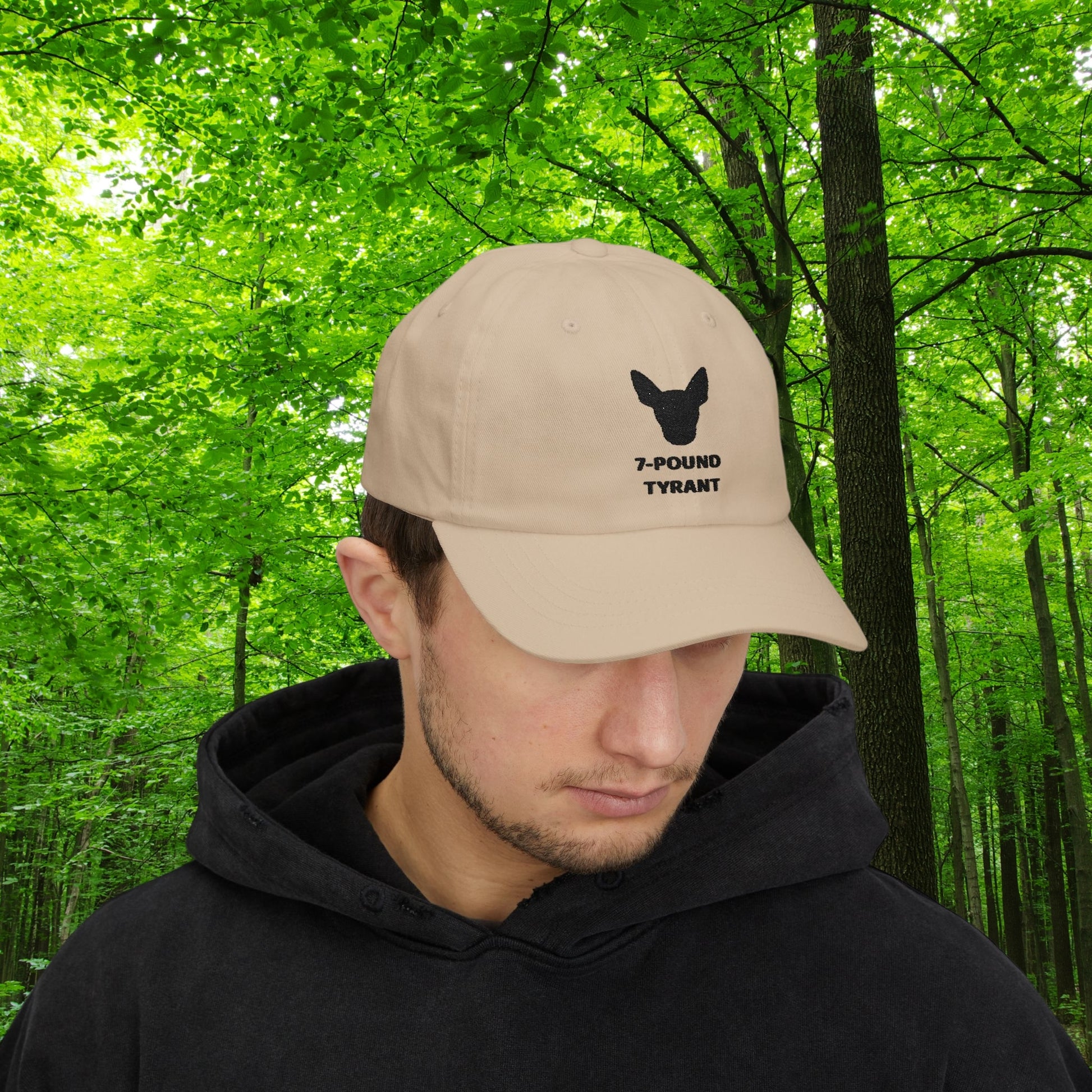 Beige "7-Pound Tyrant" Miniature Pinscher cap with black dog silhouette embroidery, worn by a man in schwarzem Hoodie