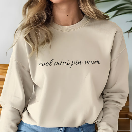Woman wearing asand "cool mini pin mom" Miniature Pinscher women’s sweatshirt, hands in pockets, casual style