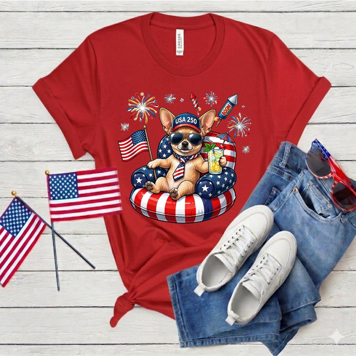Red t-shirt with a dog graphic, American flags, and sunglasses on a wooden surface.