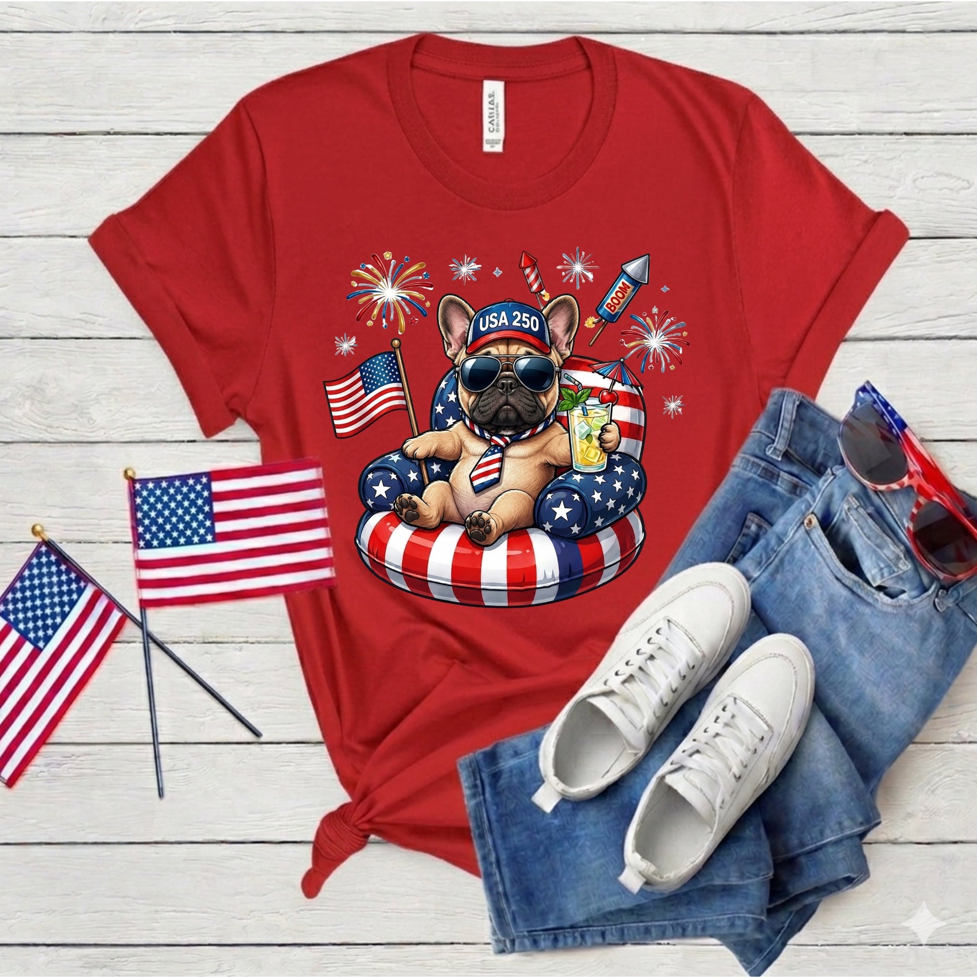 Red t-shirt with a dog graphic, American flags, and sunglasses on a wooden surface
