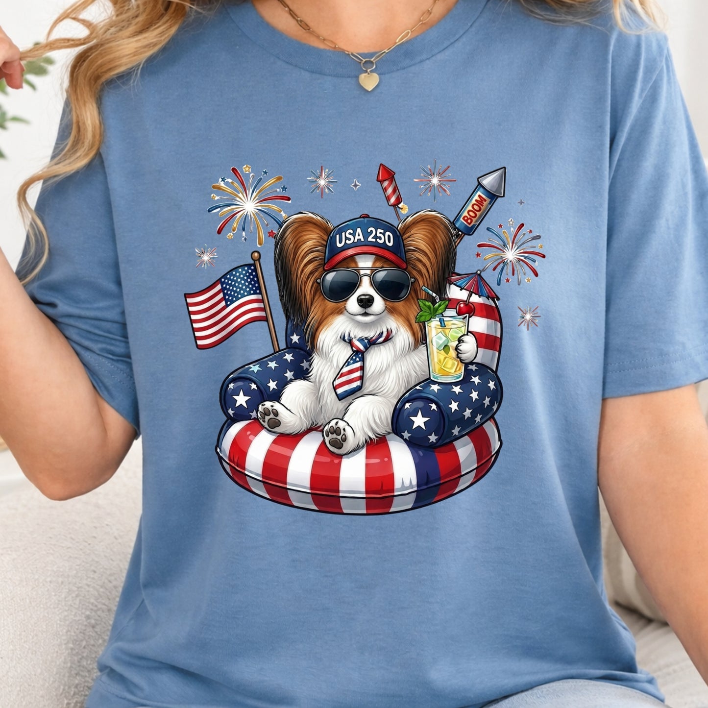 Person wearing a blue t-shirt with a dog graphic featuring American flags and fireworks.