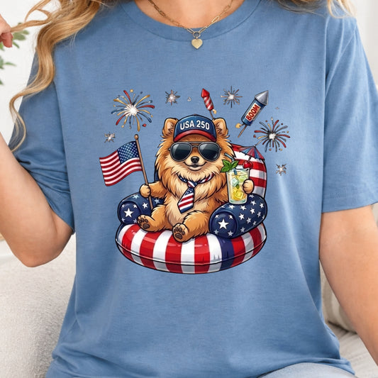 Blue t-shirt with a bear graphic holding an American flag and a drink, surrounded by fireworks and stars.