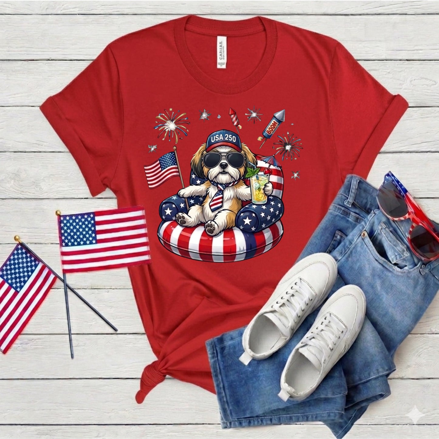 Red t-shirt with a dog graphic, American flags, and sunglasses on a wooden surface.