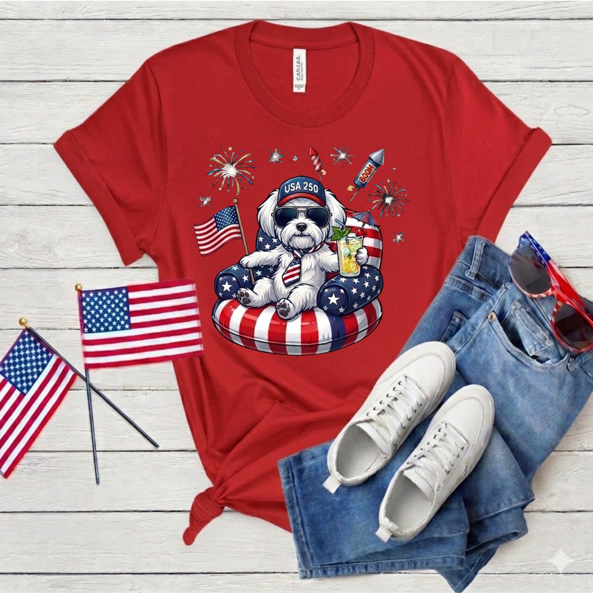Red t-shirt with a dog graphic, American flags, and sunglasses on a wooden surface