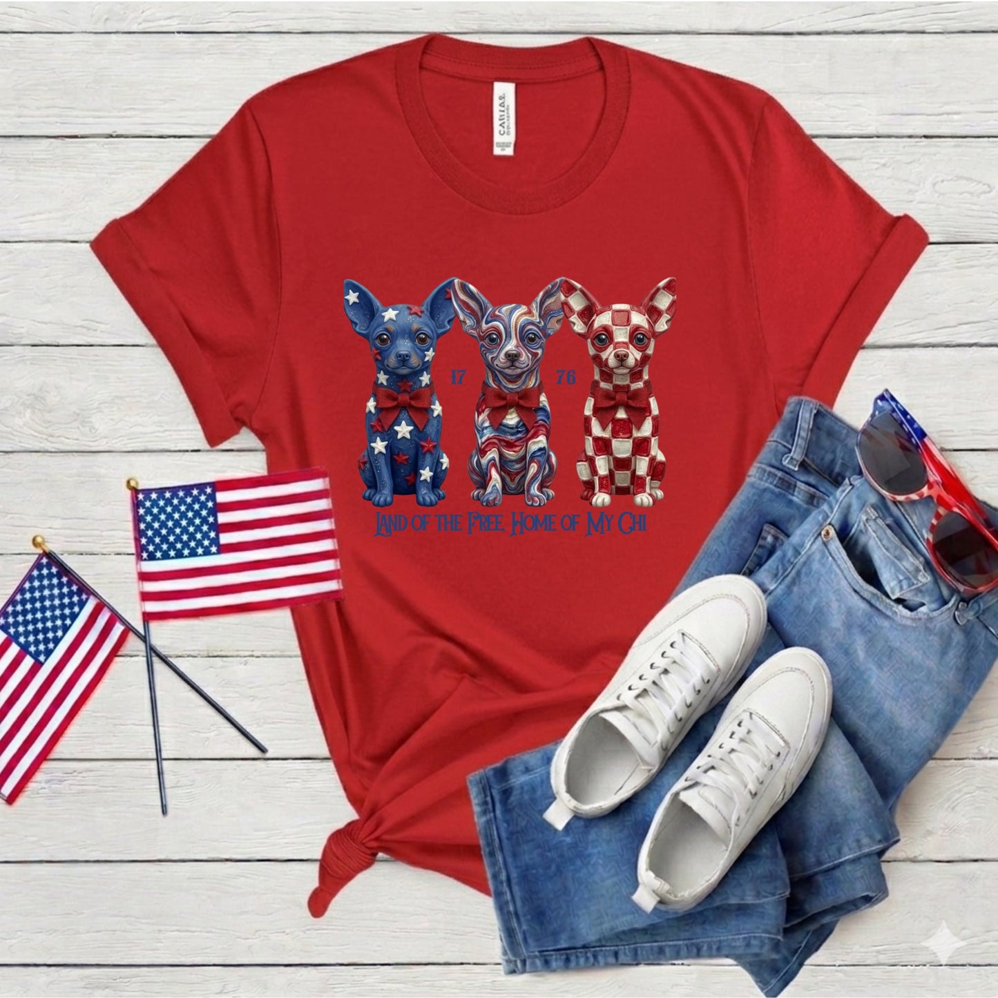 Red t-shirt with dog graphic, American flags, white sneakers, and blue jeans on a wooden surface