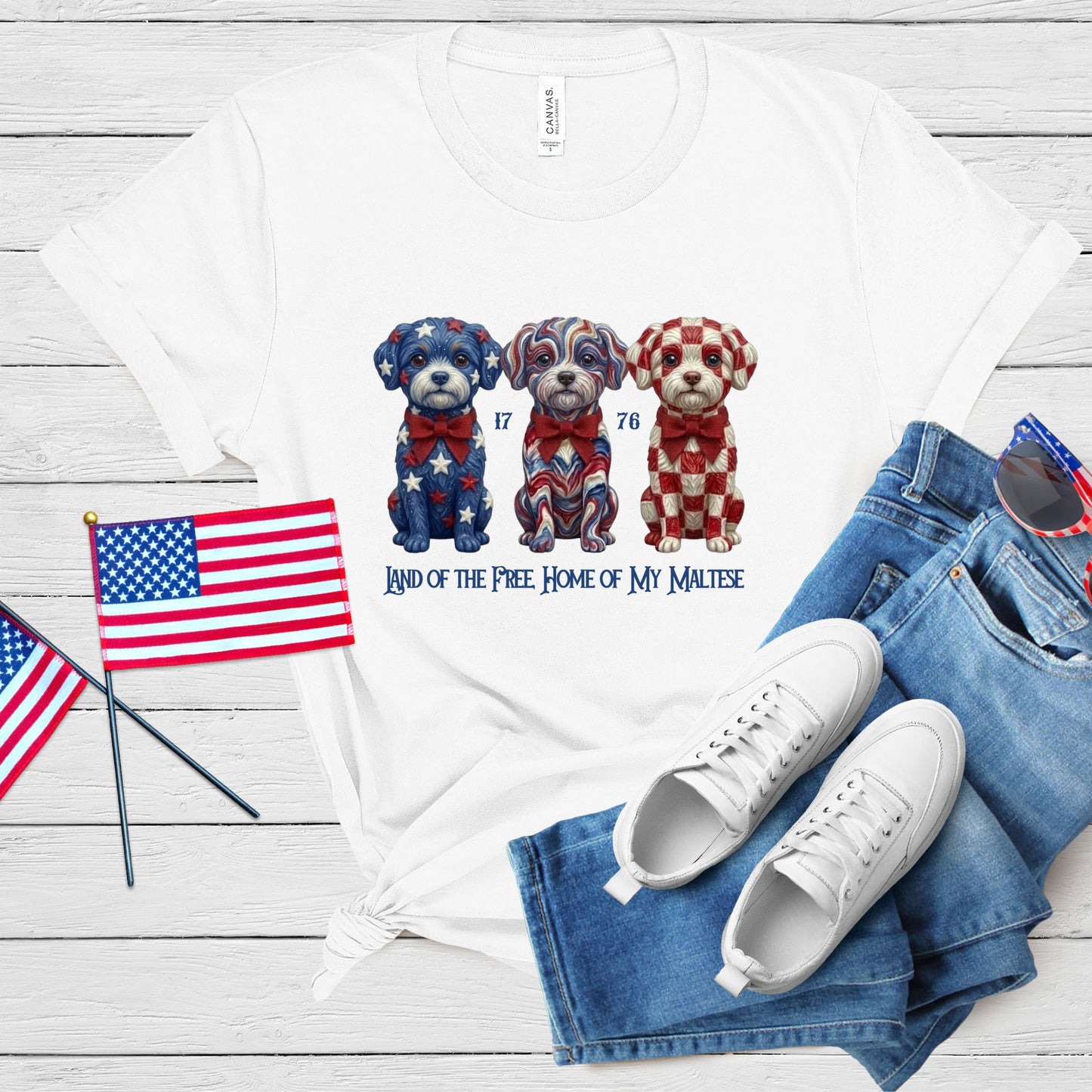 White t-shirt with dog illustrations and text, paired with jeans and sneakers on a wooden surface.