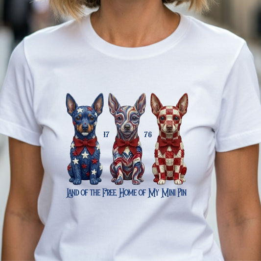 White t-shirt with three illustrated dogs in patriotic colors and text on a blurred background
