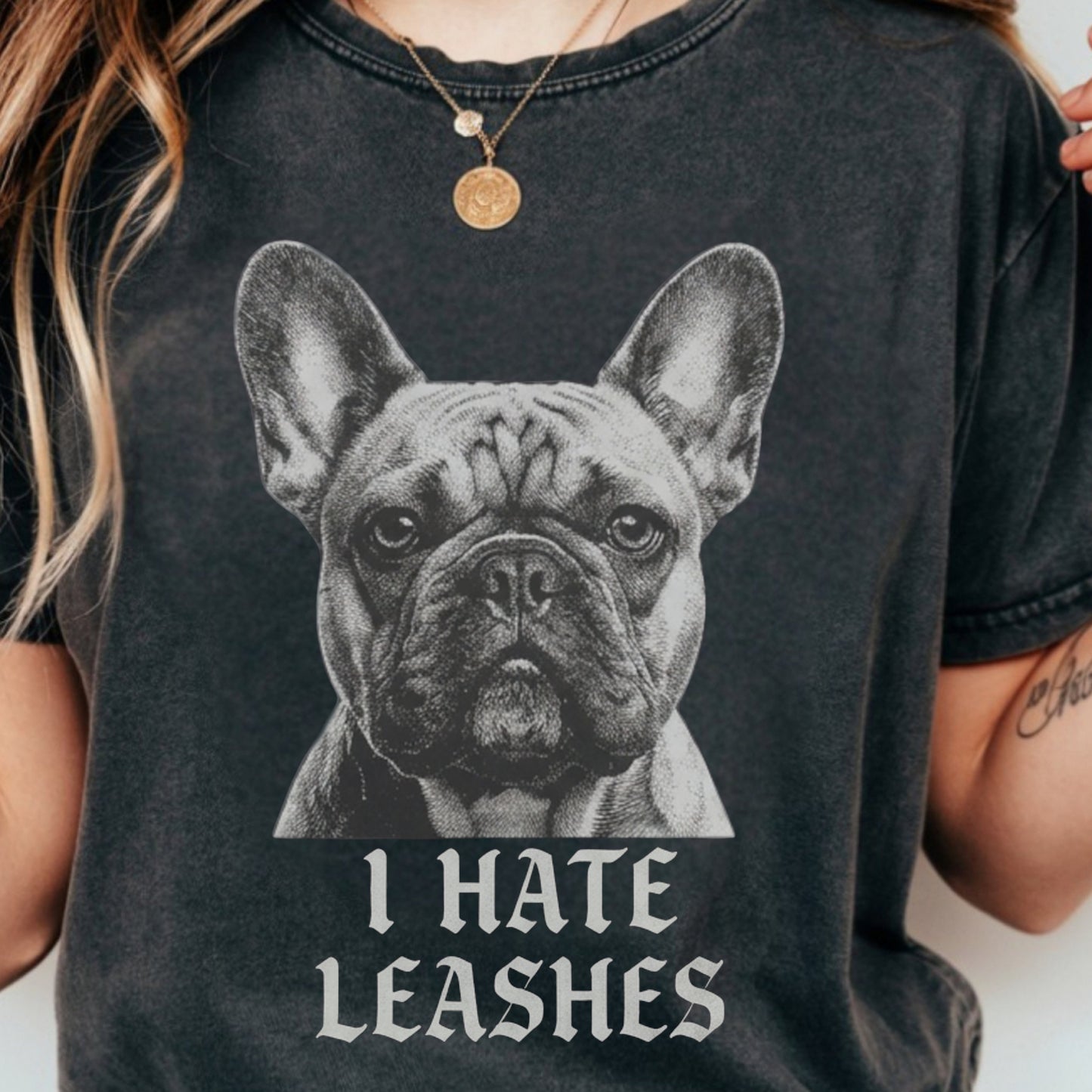 Person wearing a black t-shirt with a graphic of a dog and text 'I HATE LEASHES'.
