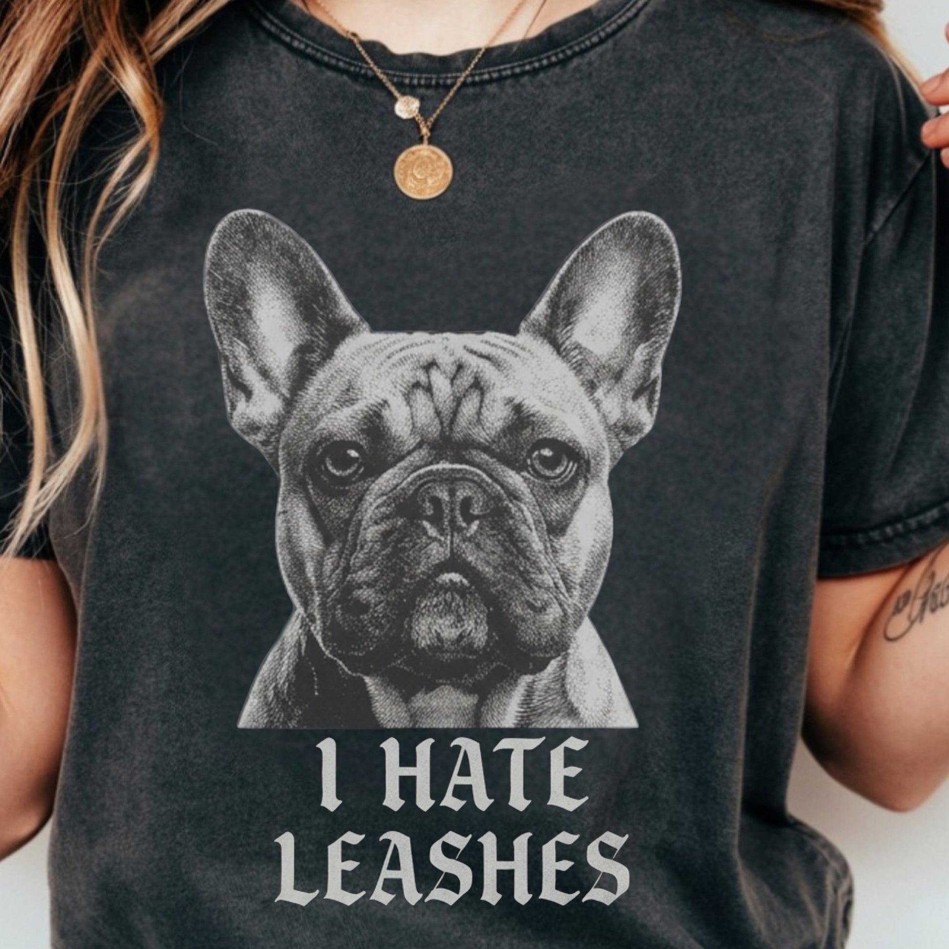 Person wearing a black t-shirt with a graphic of a dog and text 'I HATE LEASHES'.