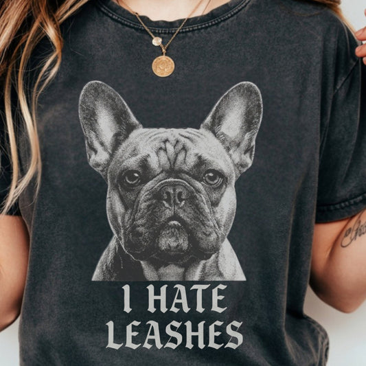 Person wearing a black t-shirt with a graphic of a dog and text 'I HATE LEASHES'.