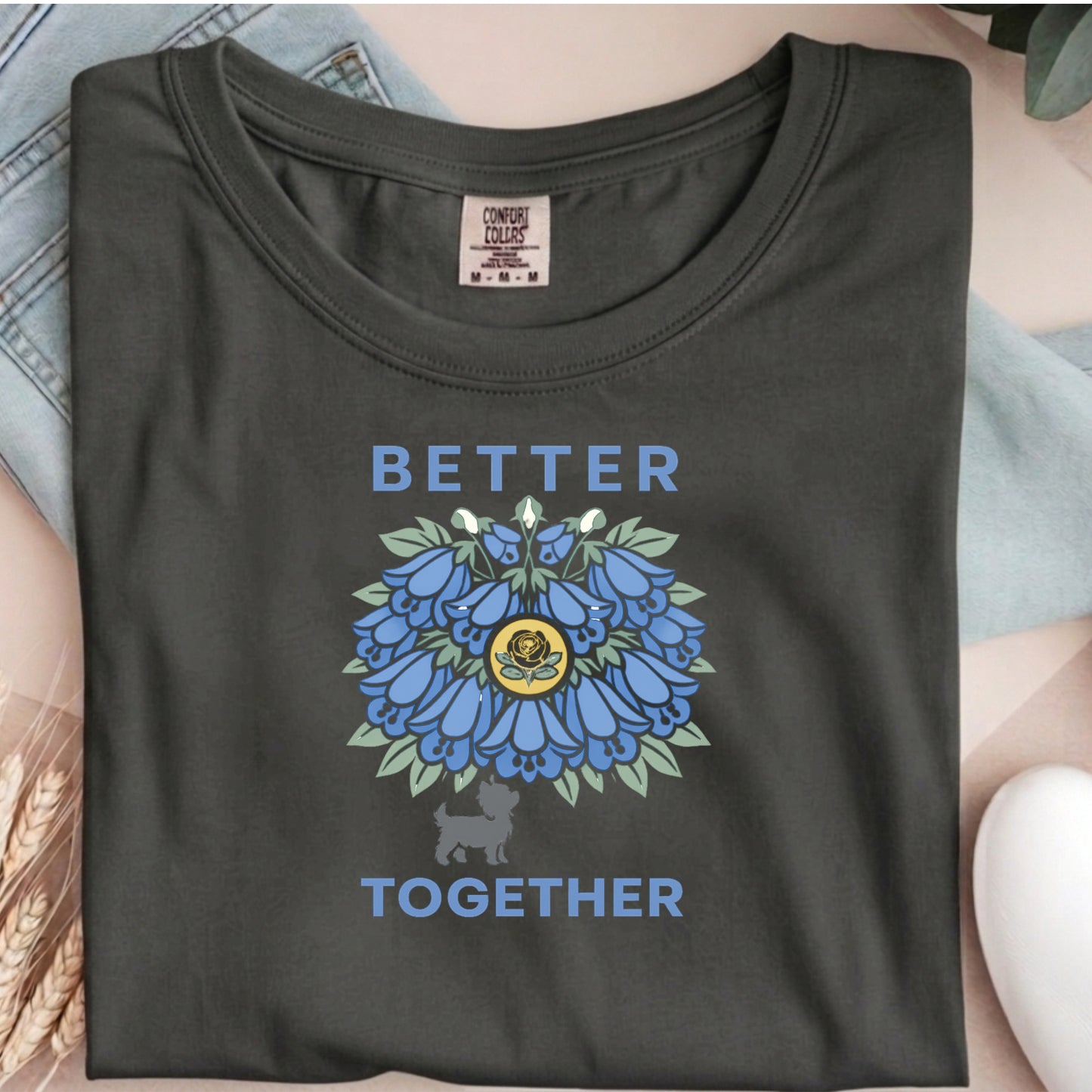 Dark gray t-shirt with blue floral design and 'Better Together' text on a textured surface.