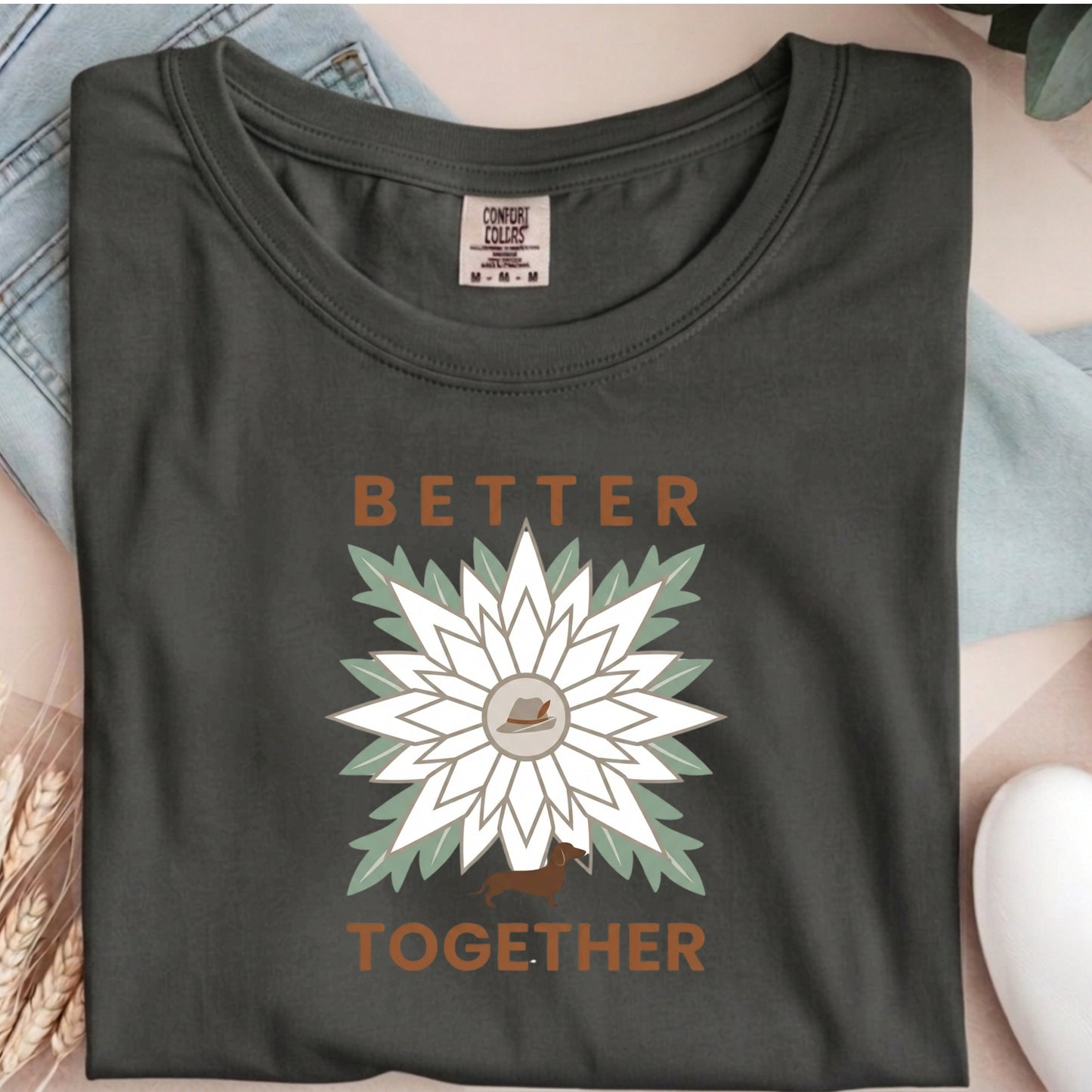 Dark gray t-shirt with a white flower graphic and 'Better Together' text on a person wearing a light blue shirt.