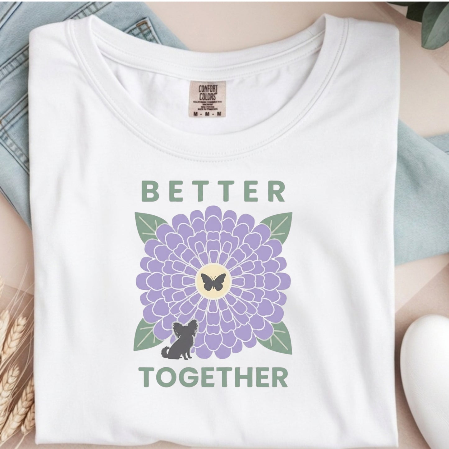 White t-shirt with a purple flower graphic and text 'Better Together' on a neutral background