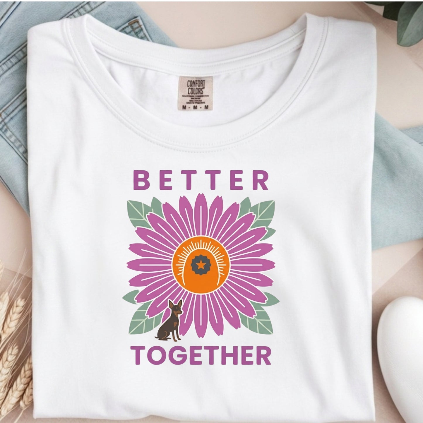 White t-shirt with a colorful flower design and 'Better Together' text on a neutral background