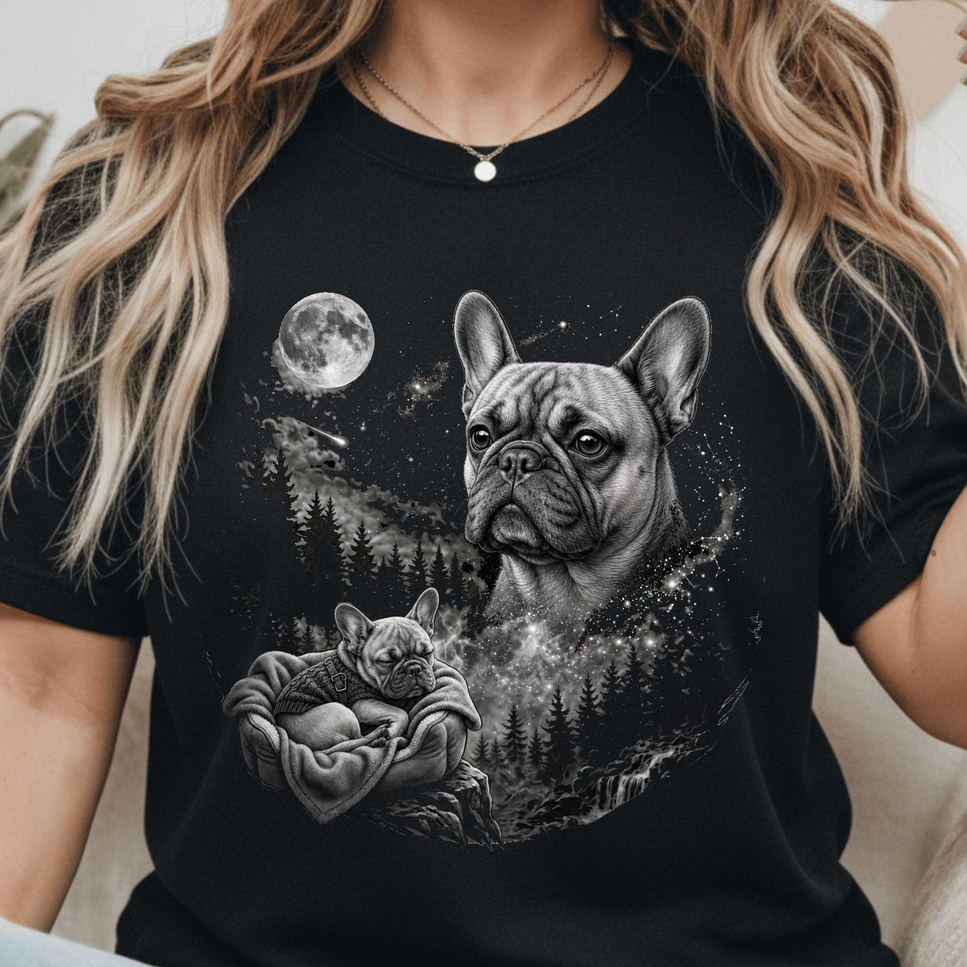 A woman wearing a black short-sleeve t-shirt with a detailed black and white graphic print of a French Bulldog and a puppy under a full moon.