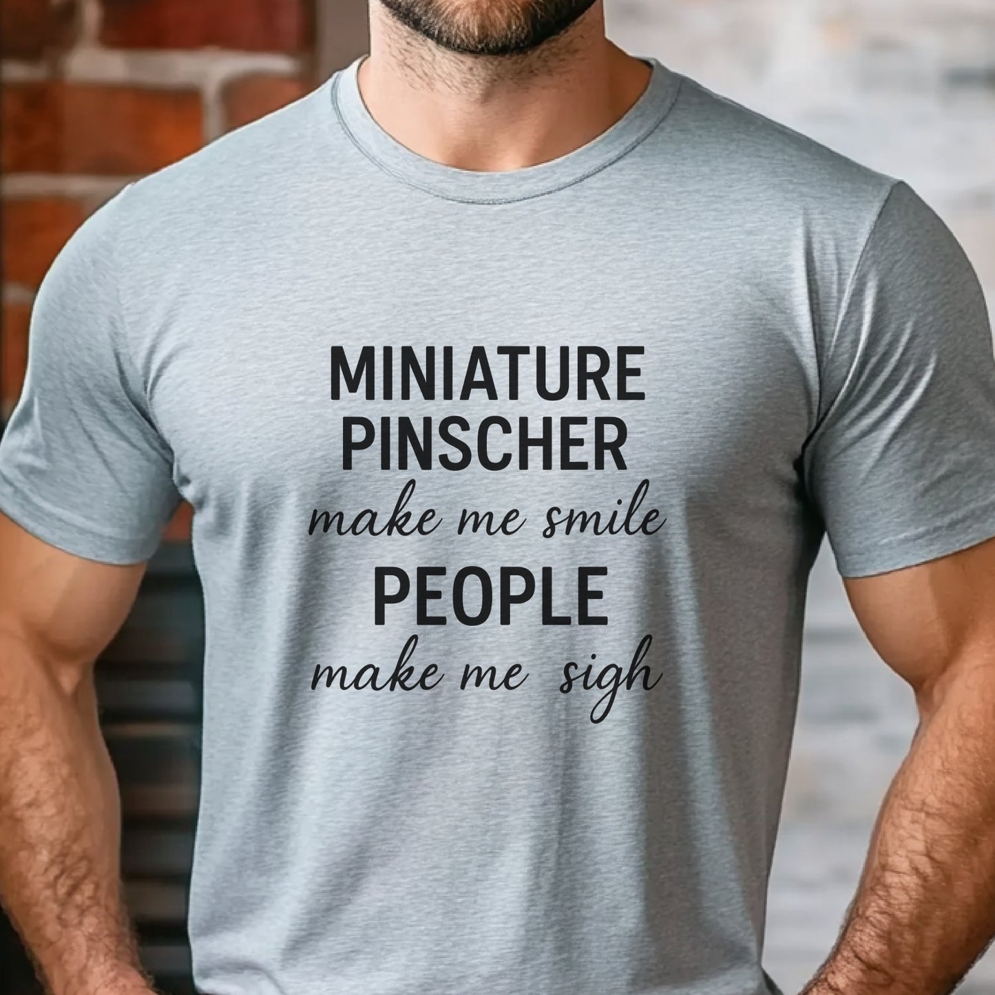 Man wearing a grey "Miniature Pinscher make me smile, people make me sigh" unisex t-shirt, casual kitchen background