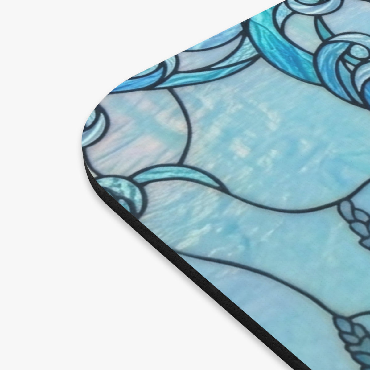 A close-up of a product corner showing a light blue and turquoise stained-glass style pattern with black outlines, photographed on a white background.