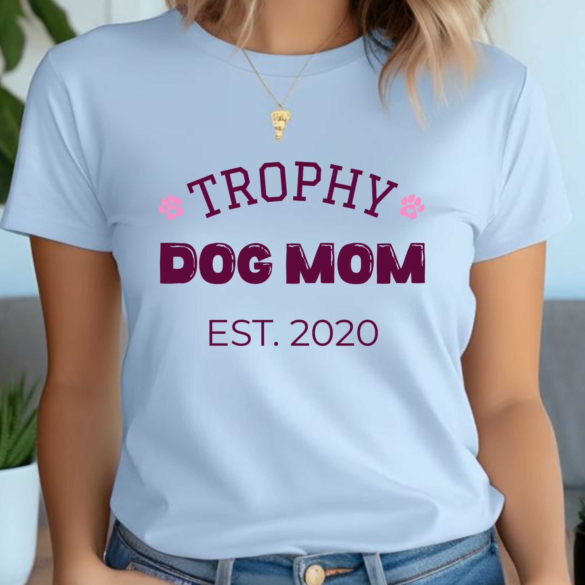 Light blue t-shirt with 'Trophy Dog Mom Est. 2020' text worn by a person.