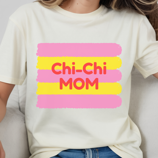 White t-shirt with 'Chi-Chi Mom' text in pink and yellow on a plain background