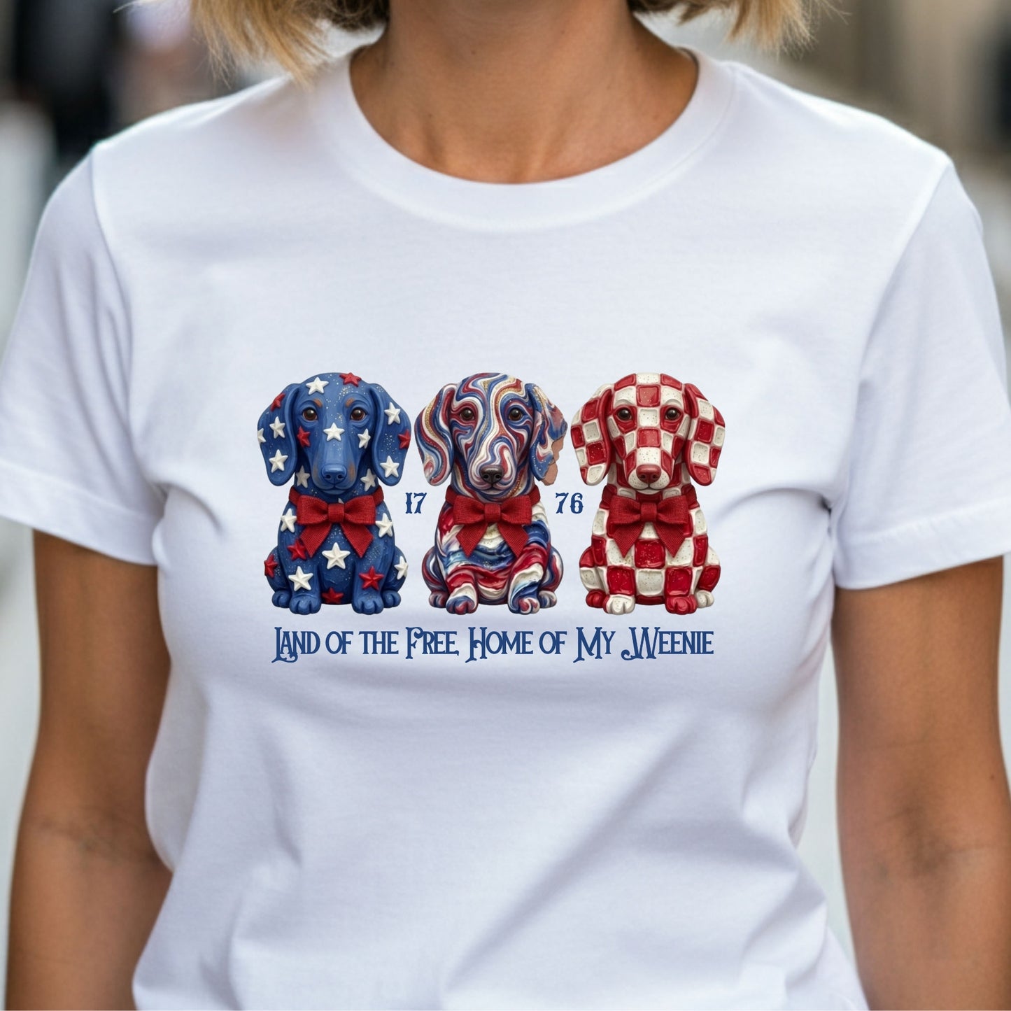 White t-shirt with colorful dog illustrations and text on a blurred background