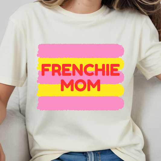 White t-shirt with 'FRENCHIE MOM' text in pink and yellow on a plain background