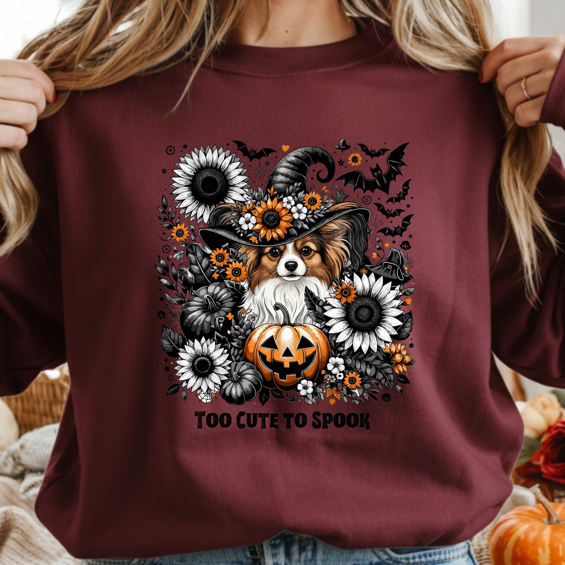 Maroon sweatshirt with a Halloween-themed design featuring a dog, pumpkin, and flowers.