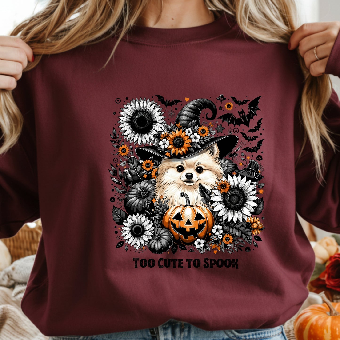 Maroon sweatshirt with a Halloween-themed design featuring a dog in a witch hat and pumpkins.