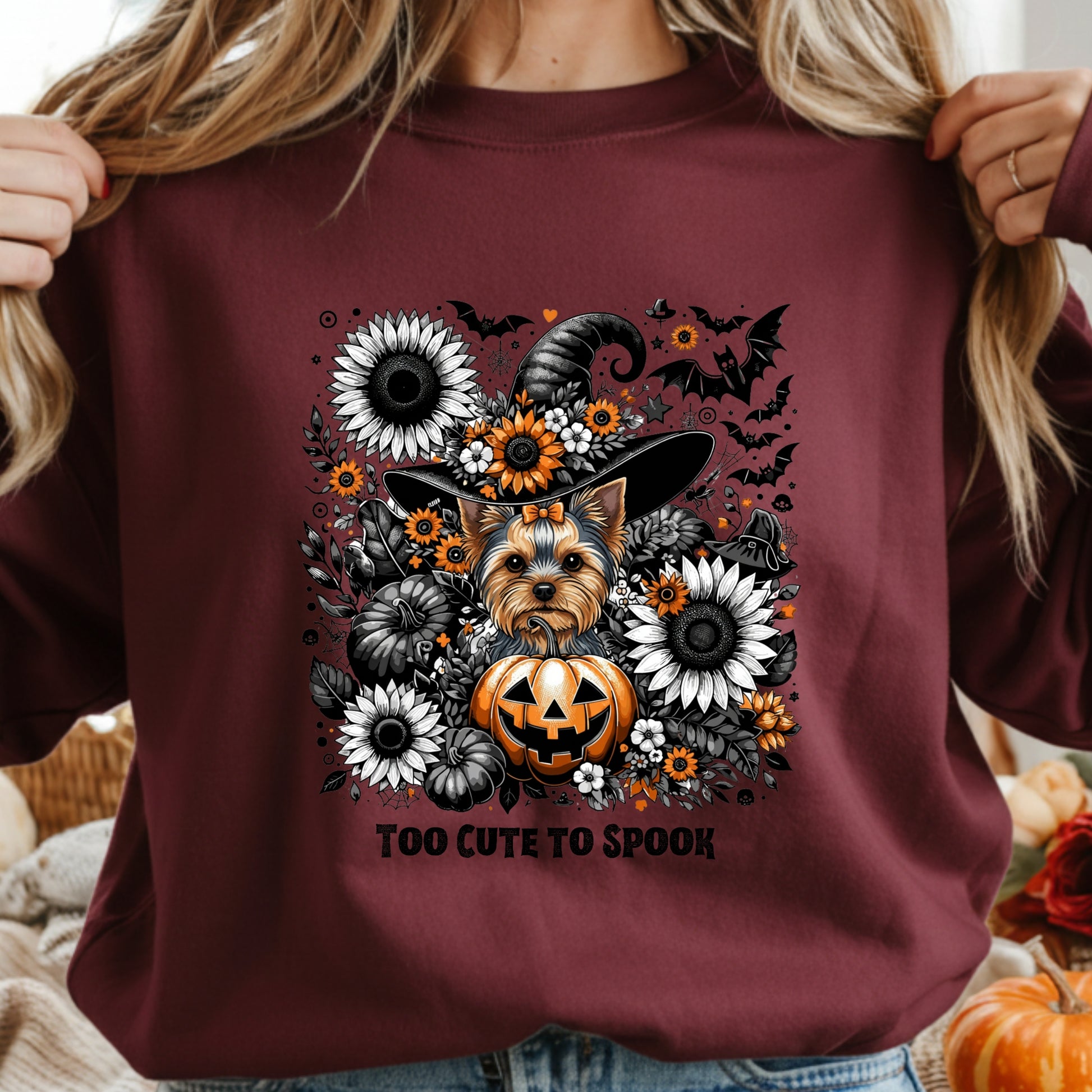 Maroon sweatshirt with a Halloween-themed design featuring a dog, pumpkins, and flowers.