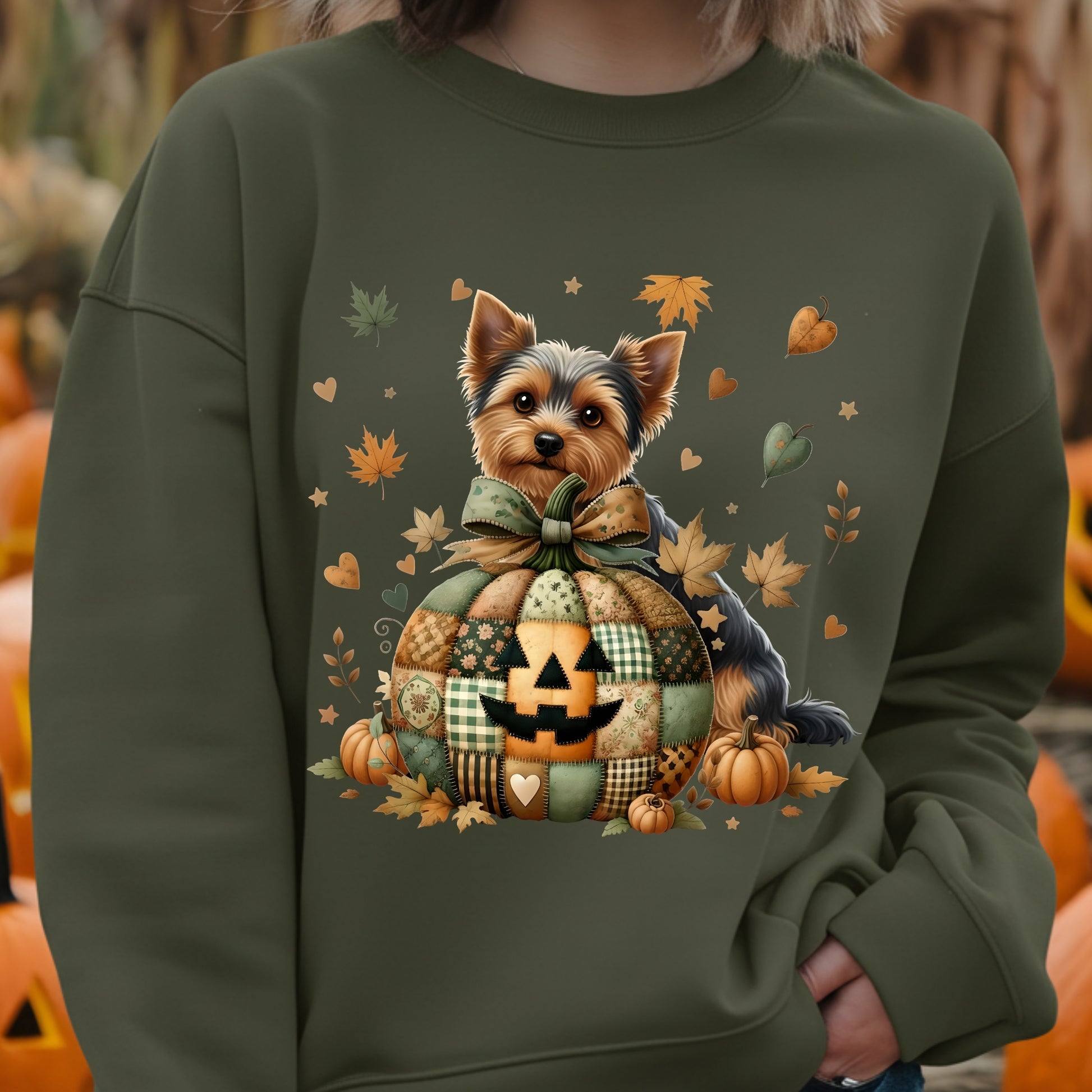 Green sweatshirt with a dog and pumpkin design, surrounded by pumpkins and autumn leaves.