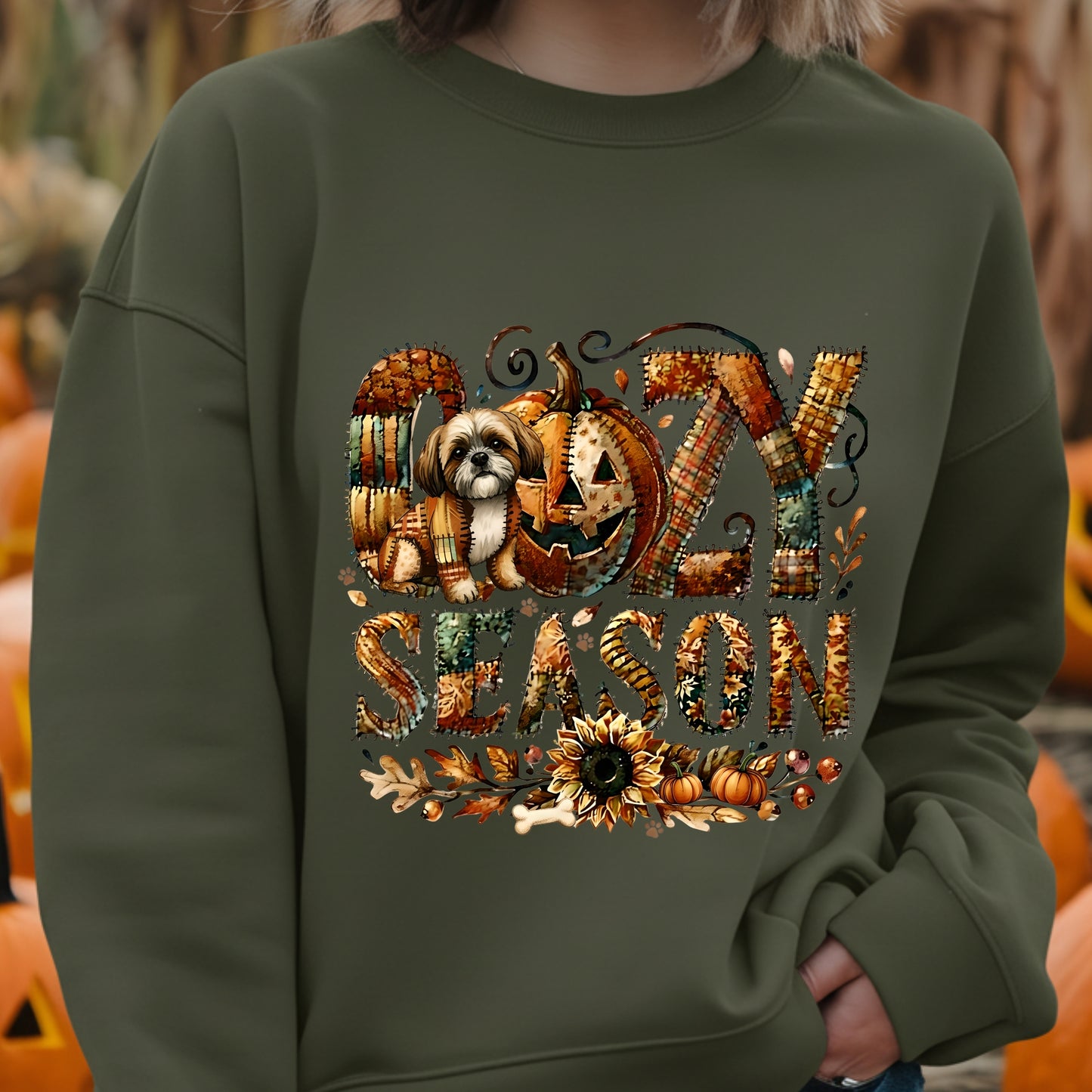 Person wearing a green sweatshirt with a Halloween-themed design featuring pumpkins and text.
