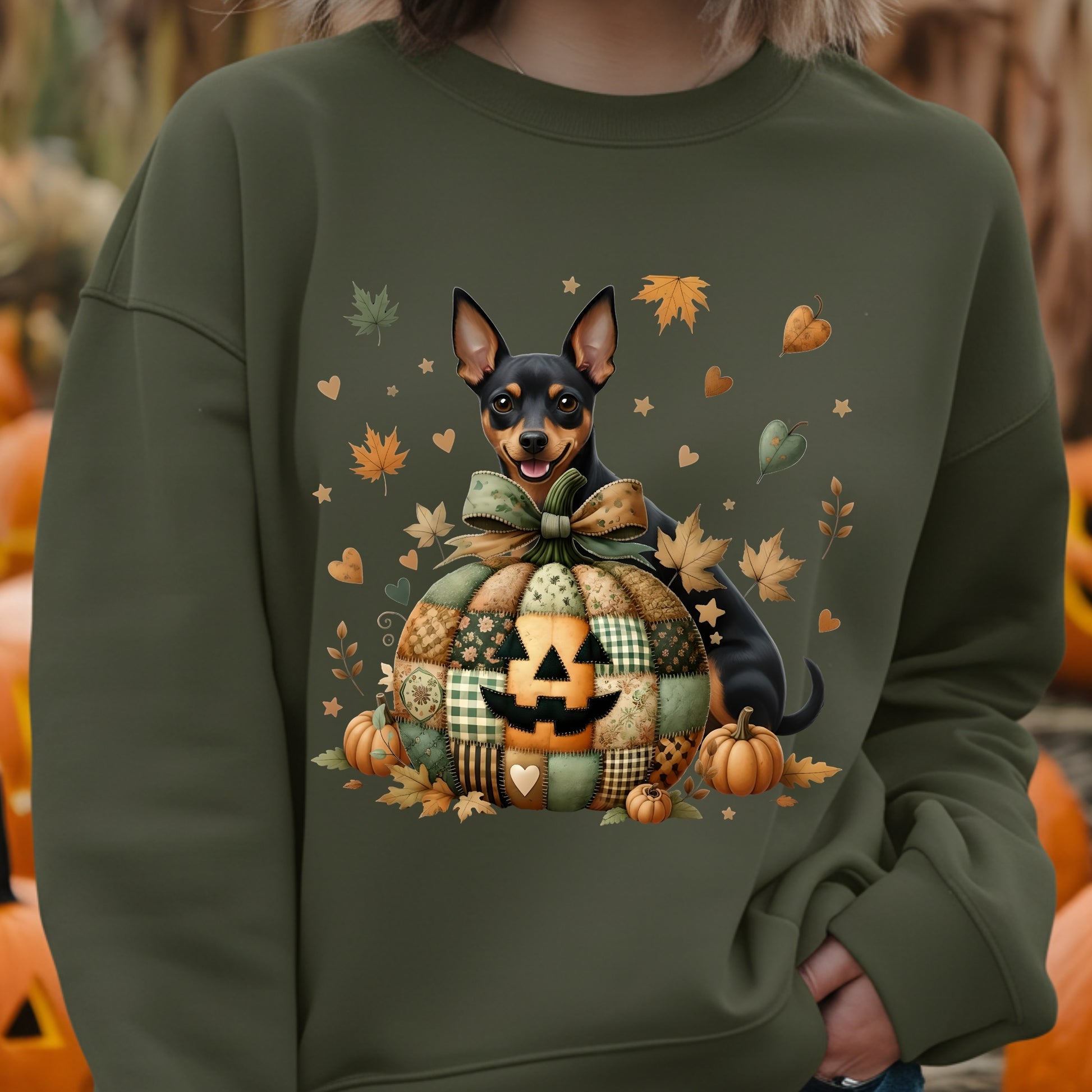 Person wearing a green sweatshirt with a dog and Halloween-themed design.
