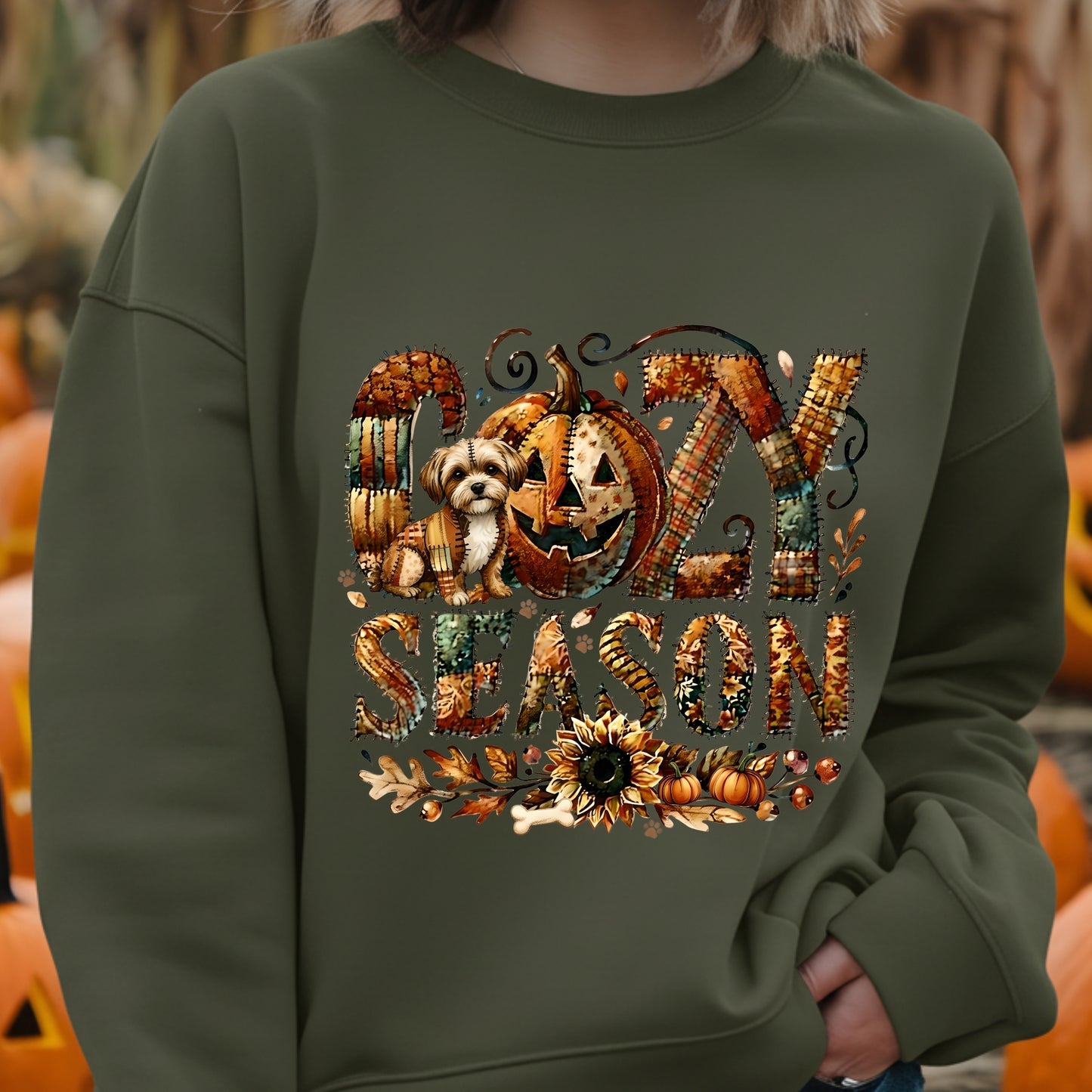 Green sweatshirt with 'Spooky Season' design featuring pumpkins and a dog, set against a blurred background of pumpkins.