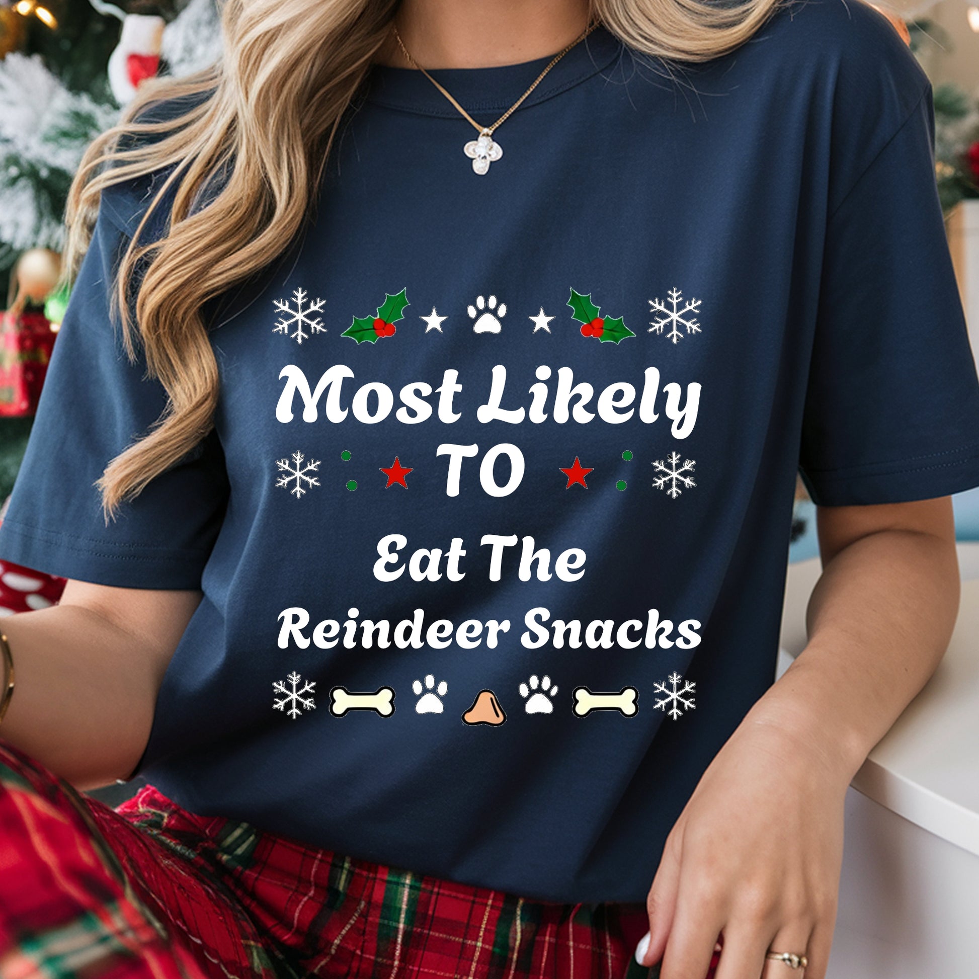 Navy blue t-shirt with Christmas-themed text and graphics worn by a person.