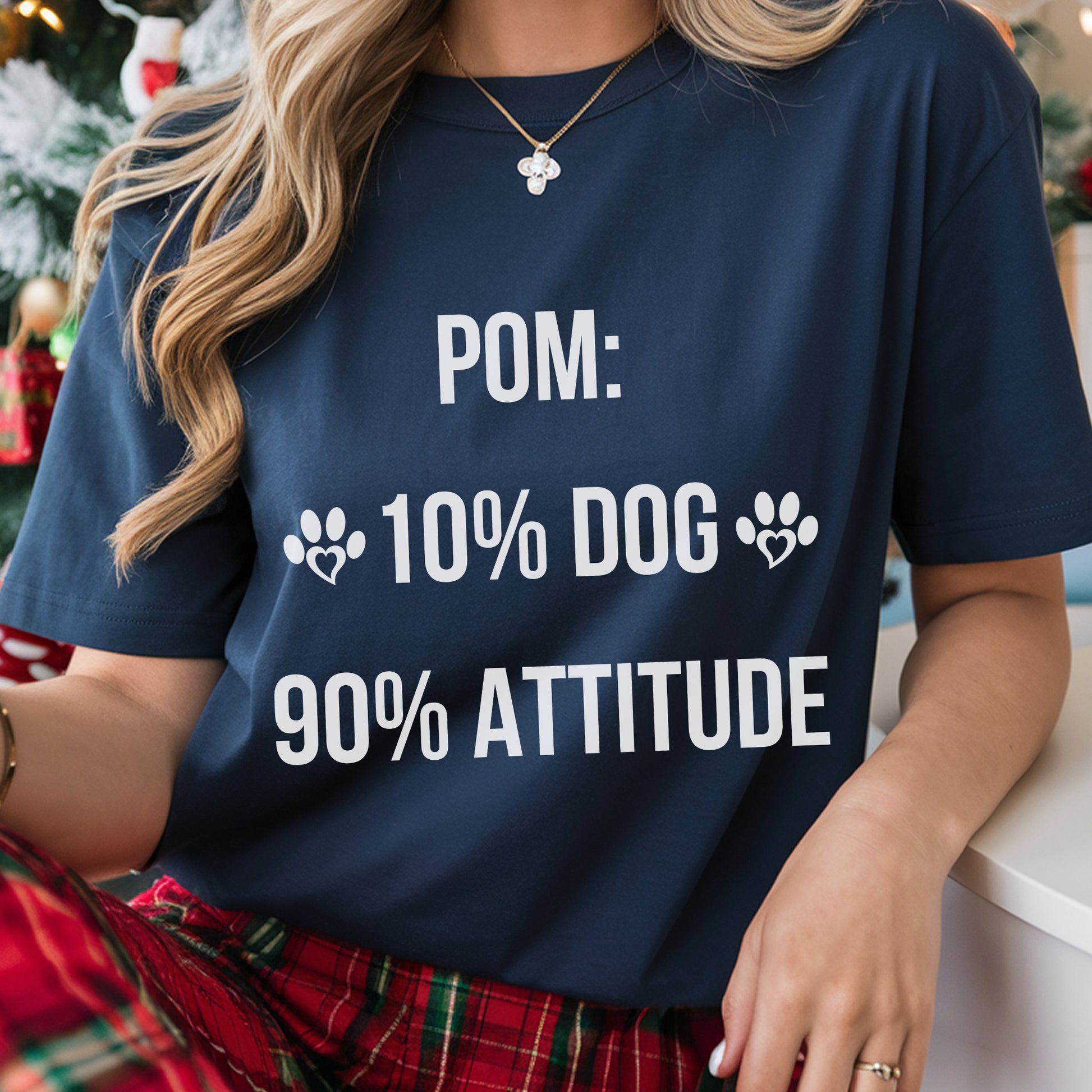 Person wearing a navy blue t-shirt with humorous text design, sitting in a festive setting.