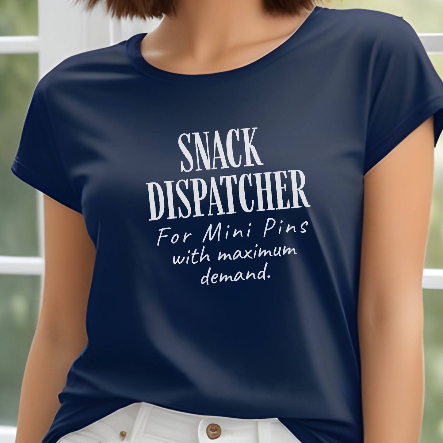 Woman wearing a navy t-shirt with black text: "SNACK DISPATCHER – For Mini Pins with maximum demand