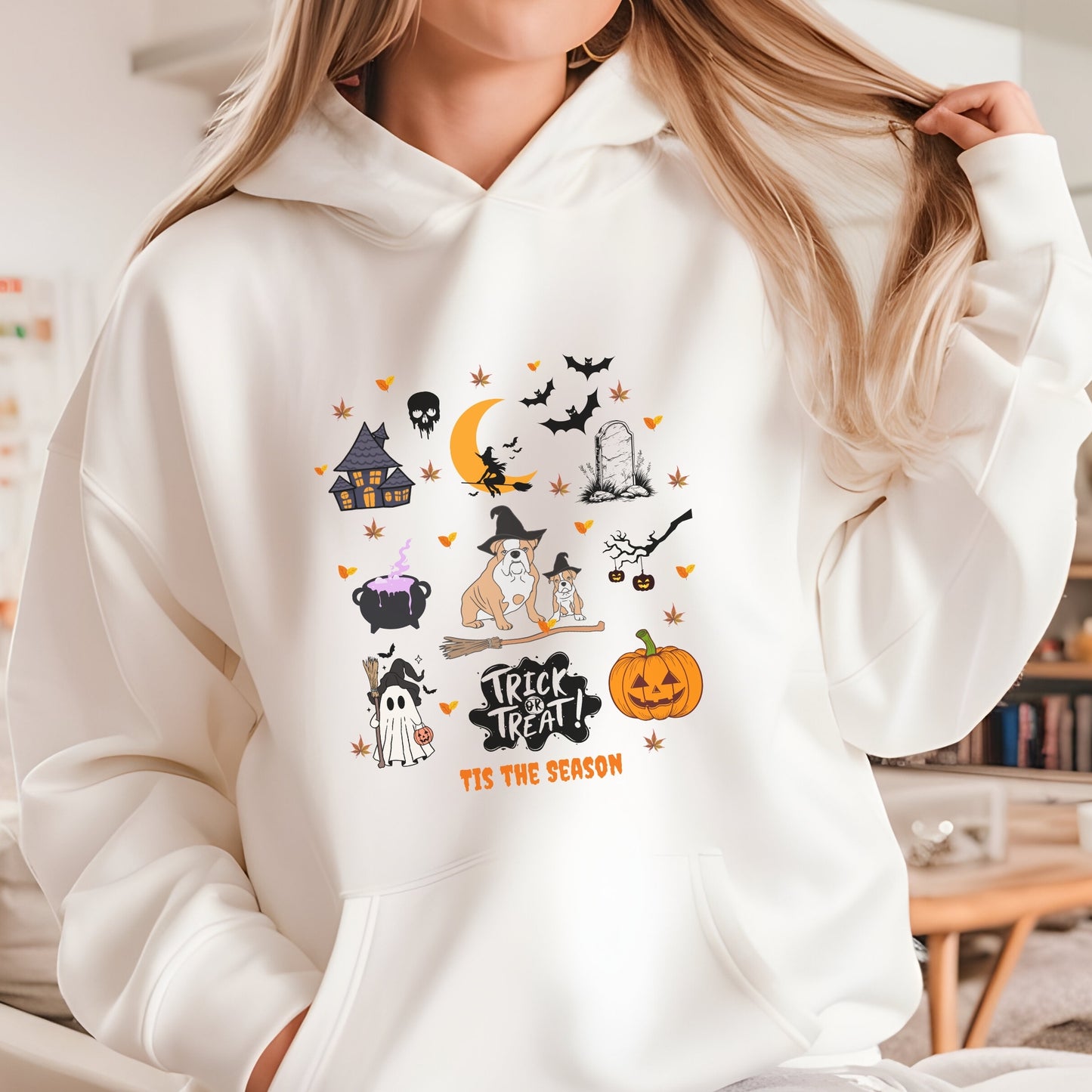 Sand hoodie with Halloween themed dog and spooky icons, “Trick or Treat ‘Tis the Season” text, festive autumn design