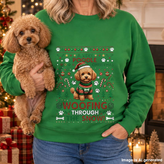 A woman wearing a bright green crewneck sweatshirt with a festive holiday graphic of a poodle wearing a Santa hat and sweater, surrounded by 'A Jolly Poochie Christmas' and 'WOOFING THROUGH SNOW!' text. She is holding a small fluffy brown poodle in a cozy holiday setting with a fireplace and Christmas decorations in the background.